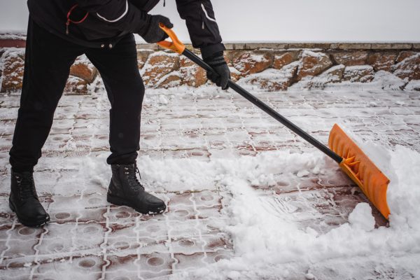 After a snowfall, a person rakes and removes snow in front of his house. Emergency, snowfall. After a snowfall, a person rakes and removes snow in front of his house. Emergency, snowfall